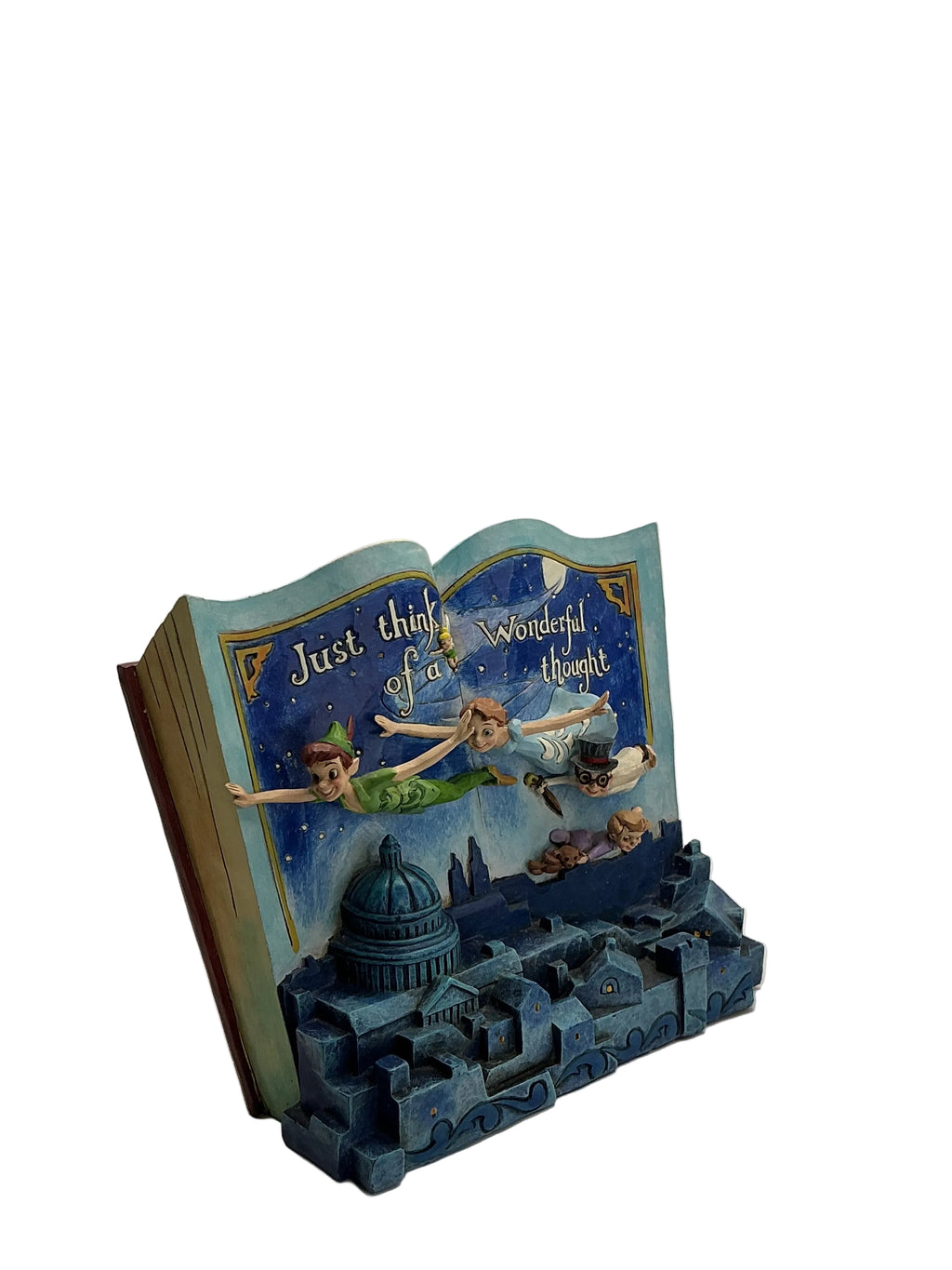 A decorative book-shaped bookend featuring Peter Pan and Tinker Bell on the cover, with a blue 3D cityscape base and the phrase 'Just think of all the wonderful things' printed on the pages.